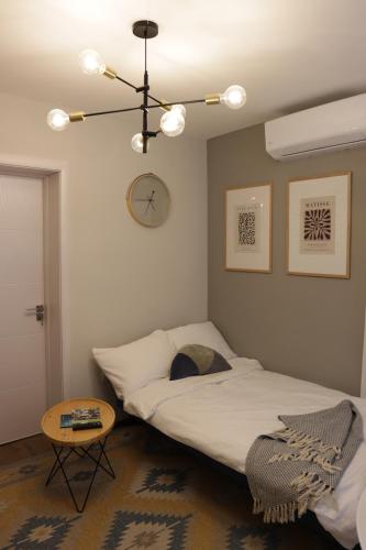 een slaapkamer met een bed en een tafel en een klok bij Vista Apartmani in Ribarska Banja