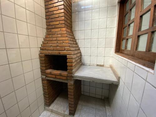 a brick oven in a bathroom with a window at Casa ao lado da praia in Barra de São Miguel