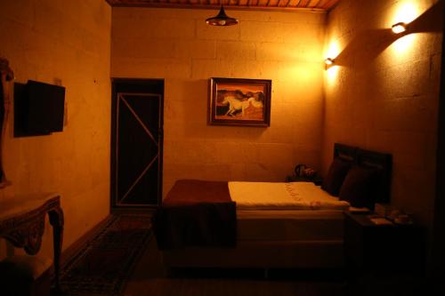1 dormitorio con 1 cama y una foto de un caballo en Antik Cave House, en Ürgüp