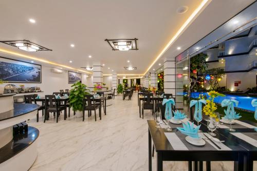 un ristorante con tavoli e sedie e una piscina di Gem Riverside Hotel Hoi An a Hoi An