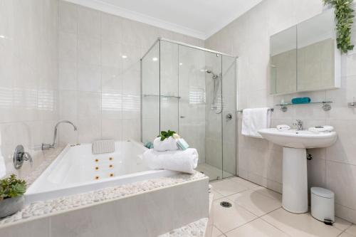 a white bathroom with a tub and a sink at The Country House at Hunchy Montville in Montville