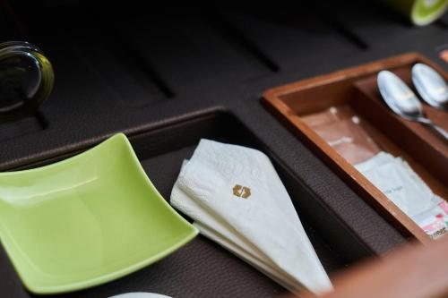 a green tray with a napkin and a box with a plate at Shangri-La Rasa Ria, Kota Kinabalu in Kota Kinabalu