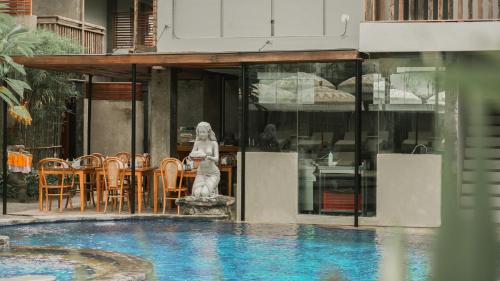 a statue of a woman standing next to a swimming pool at Annora Villas Seminyak in Seminyak