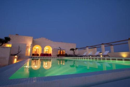 a swimming pool in front of a building at night at Villa Matera in Matera