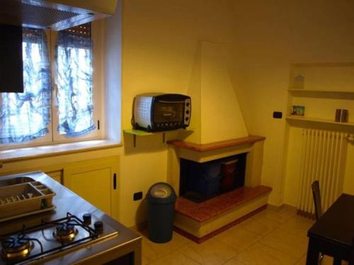 a kitchen with a stove and a tv on the wall at Casa veneto in Montalbano Ionico