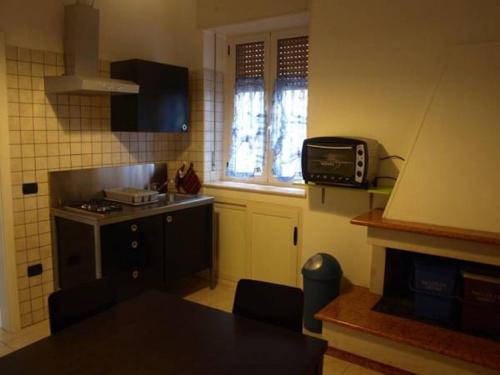 a small kitchen with a stove and a microwave at Casa veneto in Montalbano Ionico