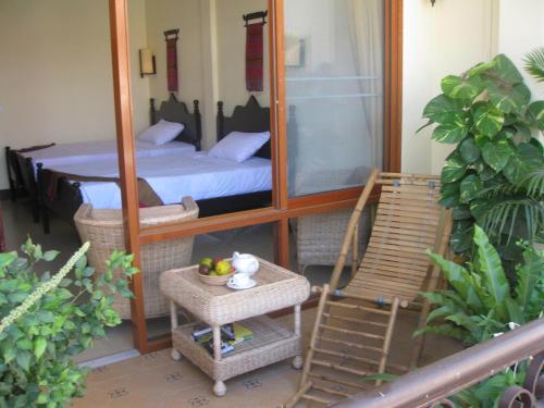 uma varanda com um espelho, uma cama e uma cadeira em Comfort House em Phnom Penh