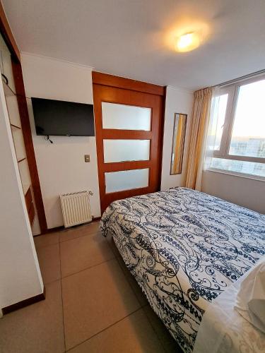 a bedroom with a bed and a window at Céntrico y cómodo departamento in Concepción