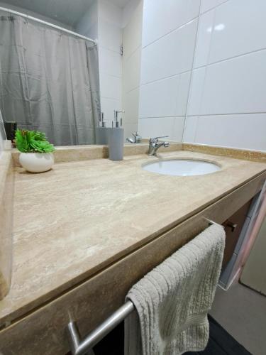 a bathroom counter with a sink and a mirror at Céntrico y cómodo departamento in Concepción