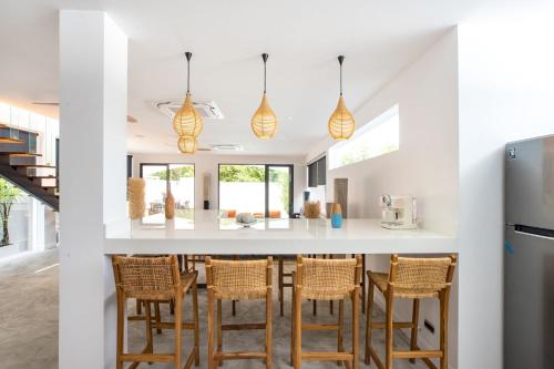 a kitchen with a bar with chairs around it at New & Elegant 5Br Pool Villa Samakki Garden 5 in Rawai Beach