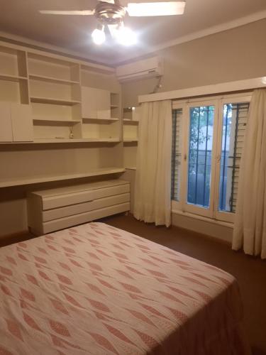 1 dormitorio con cama y ventana en Tu casa en el centro en San Rafael