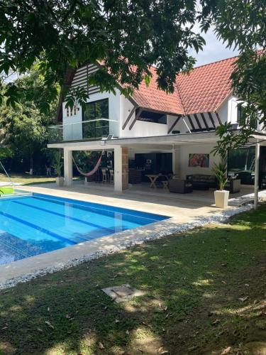 a house with a swimming pool in front of a house at Cabaña en santafe de Antioquia in Santa Fe de Antioquia