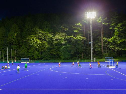 a group of children playing soccer on a court at night at MOBILITA COURT IWATE in Hachimantai