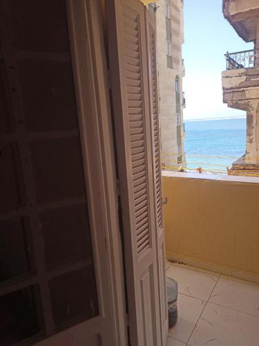 una porta aperta su un balcone con vista sull'oceano di Payment by cash or cash only and no aplace a Abū Qīr