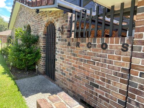 a brick wall with a gate on the side of a house at Arcos in Hat Head