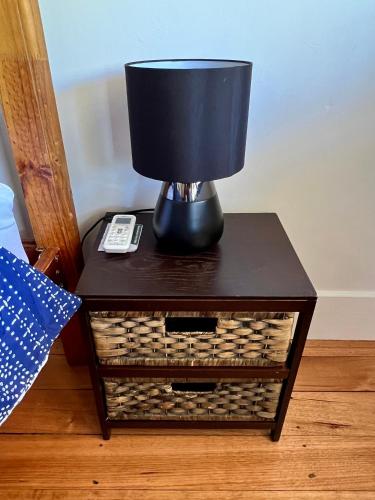 a lamp on a table next to a bed at Nilmar Ave - Central Cozy 1950s Wodonga 3br Cottage in Wodonga