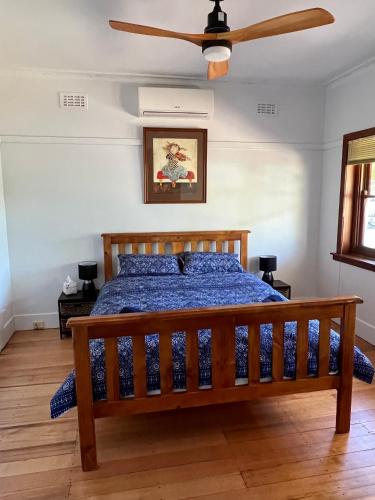 a bedroom with a bed and a ceiling fan at Nilmar Ave - Central Cozy 1950s Wodonga 3br Cottage in Wodonga