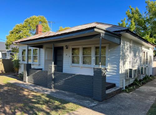 a small white house with a roof at Nilmar Ave - Central Cozy 1950s Wodonga 3br Cottage in Wodonga