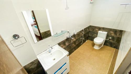 uma casa de banho com um lavatório, um WC e um espelho. em Heaven Stay em Port Blair