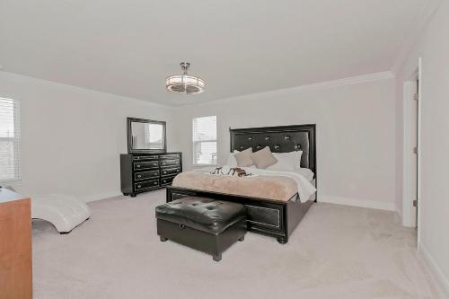 Spacious 4 Bed Home near Orlando Gated Pool Access في سانفورد: غرفة نوم بسرير كبير وكرسي