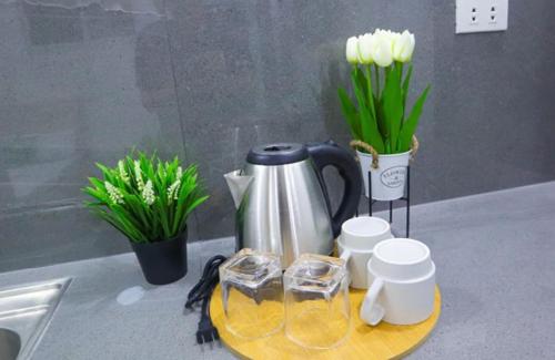 a coffee pot on a tray on a counter with flowers at Brand New Cozy Condotel in Olongapo