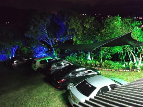 twee auto's geparkeerd in een tuin 's nachts bij LA BENDICION in Cali