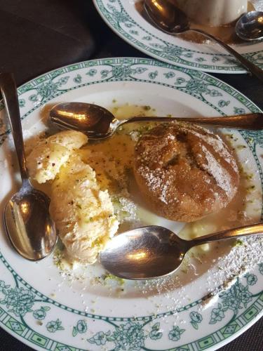 a plate of food with two spoons on a table at CasaPaola b&b Rooms in Acireale