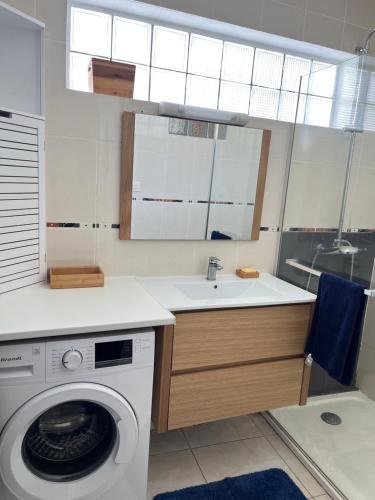 eine Küche mit einer Waschmaschine und einem Waschbecken in der Unterkunft Bel appart Étang salé La réunion in L'Étang-Salé-les-Bains