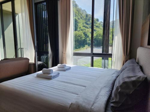 a bedroom with a large bed with towels on it at A2 at Forest Khaoyai in Ban Huai Sok Noi