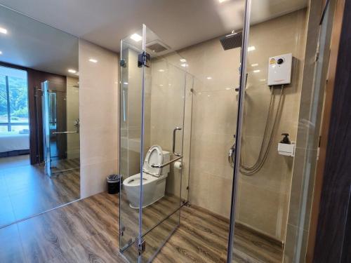 a bathroom with a glass shower with a toilet at A2 at Forest Khaoyai in Ban Huai Sok Noi