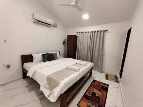 a bedroom with a large bed in a room at WhiteHouse Homestay by Oxystays Hospitality in Alibaug