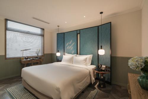 a bedroom with a large white bed and a window at La Passion Hanoi Hotel & Spa in Hanoi