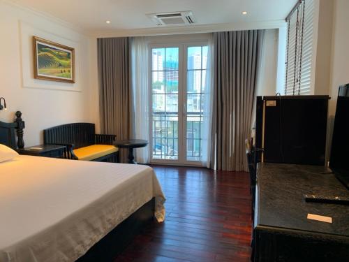 une chambre d'hôtel avec un lit et des portes coulissantes en verre dans l'établissement My Stay Hotel & Apartment, à Hô-Chi-Minh-Ville