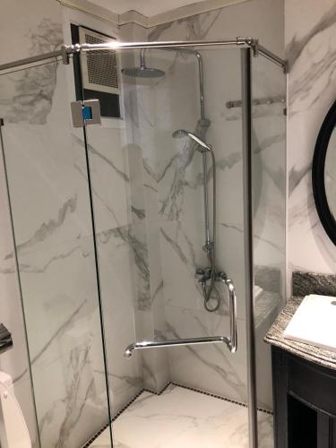 a shower with a glass door in a bathroom at My Stay Hotel & Apartment in Ho Chi Minh City