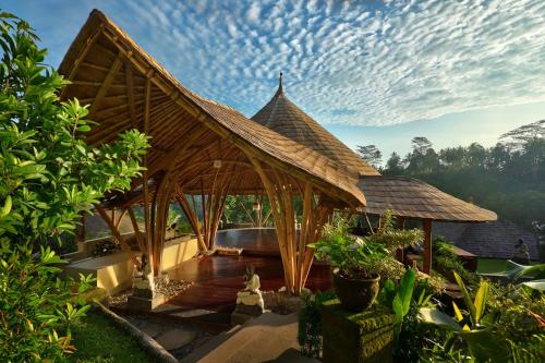 a pavilion with a roof on top of a house at Jannata Resort and Spa in Ubud