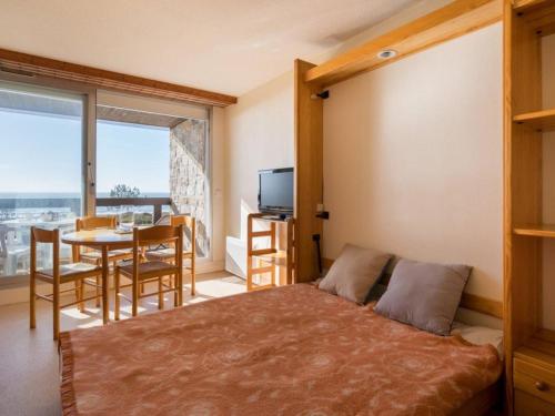 une chambre avec un lit et une salle à manger avec une table dans l'établissement Carnac - Studio cabine face plage avec parking - 4 pers - FR-1-477-81, à Carnac