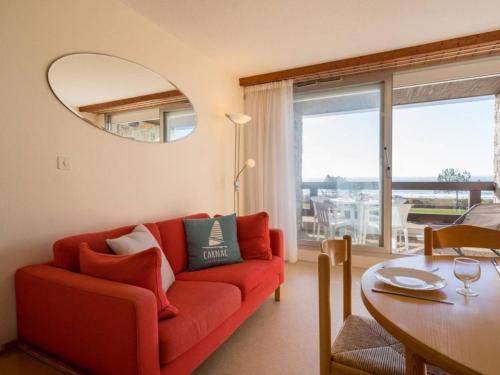 un salon avec un canapé rouge et une table dans l'établissement Carnac - Studio cabine face plage avec parking - 4 pers - FR-1-477-81, à Carnac