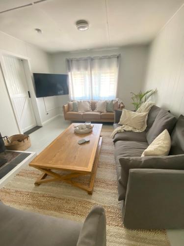a living room with a couch and a coffee table at Stay Salty in Culburra Beach