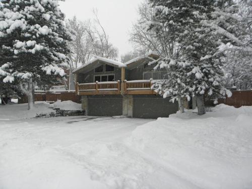 Cottonwood HeightsFour resorts within 20 minutes from your door step!!的两棵树前的雪覆盖的房子