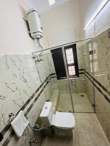 a bathroom with a toilet and a window at Hotel Majestic in Kolkata