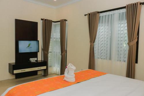 a white cat statue sitting on a bed in a bedroom at Argya Santi Resort in Jimbaran
