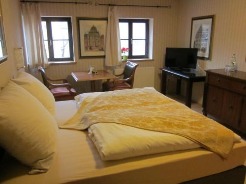 a bedroom with a large bed with a desk and a piano at Hotel Schlossresidenz Heitzenhofen in Duggendorf