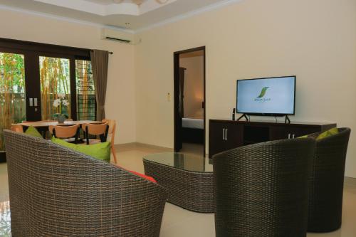 a living room with wicker chairs and a television at Argya Santi Resort in Jimbaran