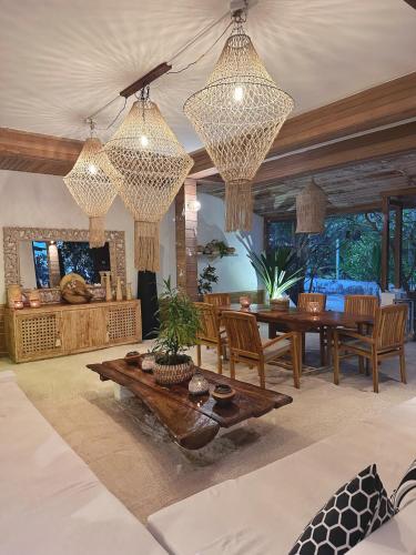 a living room with a table and chairs and chandeliers at Iru Maldives in Thulusdhoo