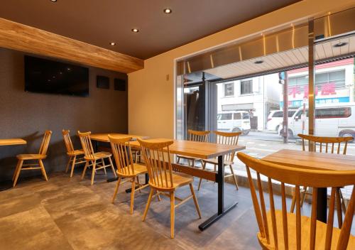 a restaurant with wooden tables and chairs and a window at APA Hotel Koriyama Ekimae in Koriyama