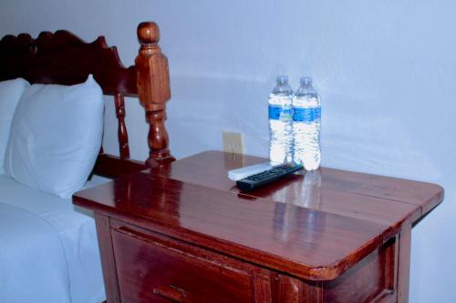 zwei Flaschen Wasser auf einem Tisch neben einem Bett in der Unterkunft NICTE-HA in Xpujil