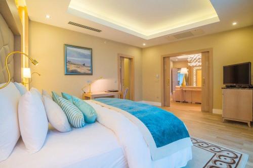 a bedroom with a large bed with blue and white pillows at Badamdar Hotel and Residences in Baku
