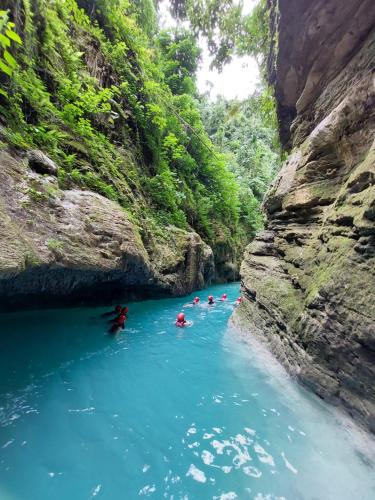 a group of people swimming in a river in a canyon at Hotel Sisters Inn in Moalboal