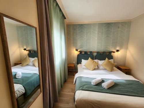 a hotel room with two beds and a mirror at Kalia Kibbutz Hotel in Kalia