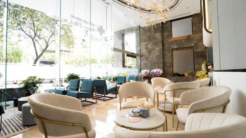 a restaurant with white chairs and tables and windows at Celine Living - Central in Ho Chi Minh City
